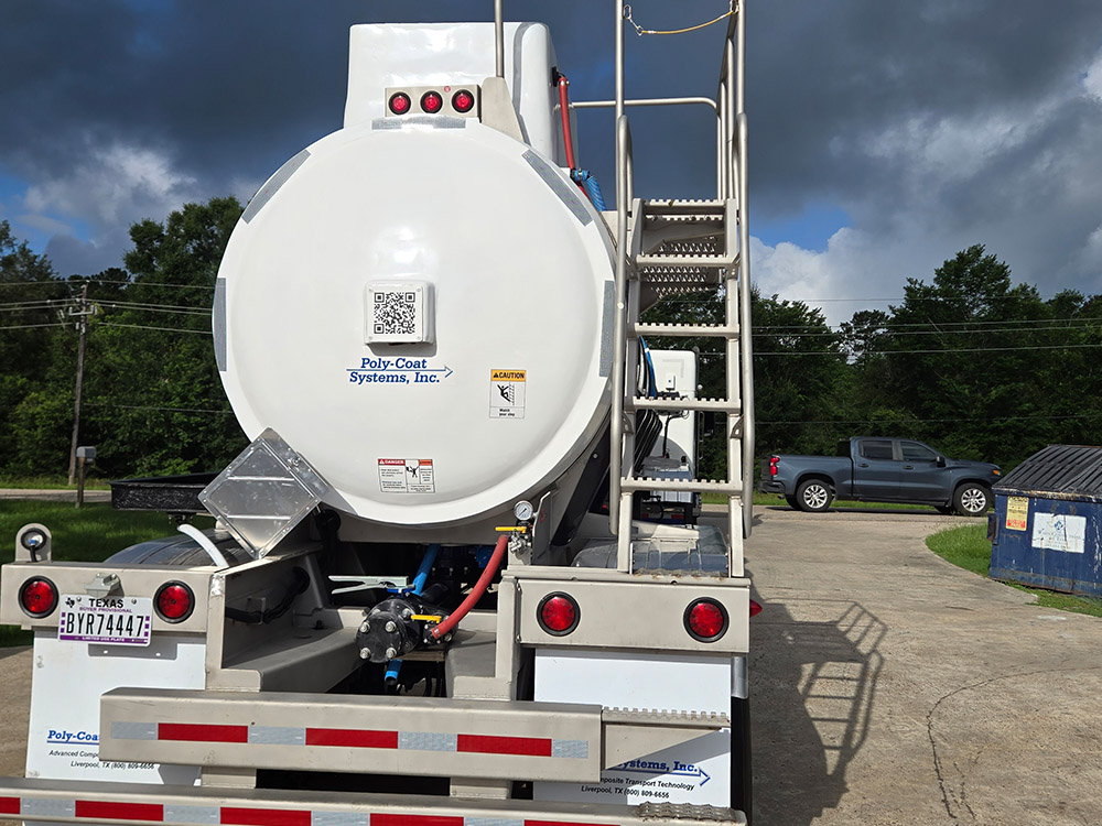 Rear view of a stock tank trailer from Poly-Coat Systems showing the ladder, piping and trailer frame.