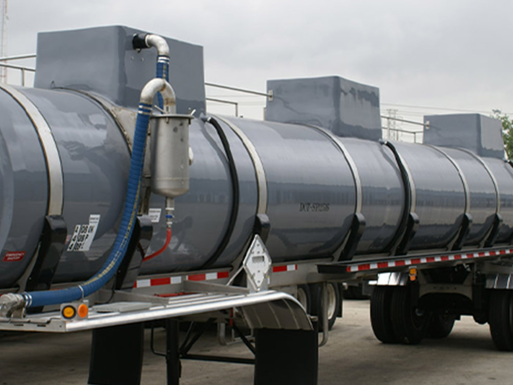 Vacuum tank trailer featured by Poly-Coat Systems with vacuum hose, piping and separator canister visible.